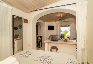 a bedroom with a bed and a table with a laptop at COTTAGE BLUE in Pylos