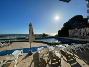 a group of chairs and an umbrella next to a swimming pool at VADIGI COCHOA in Viña del Mar