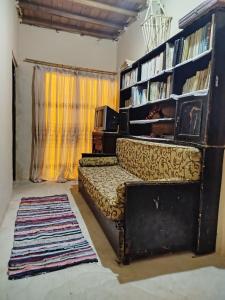 a living room with a couch and a book shelf at Wenarose house in Siwa