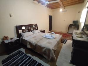 a bedroom with a large bed and two tables at Wenarose house in Siwa