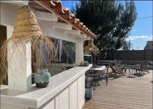 a patio with tables and chairs on a wooden deck at Rêve Capestanais - B&B avec Piscine in Capestang