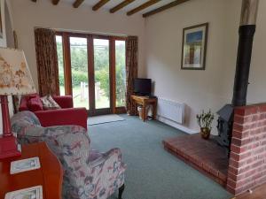 a living room with a couch and a fireplace at Nethergate Cottage, Westerclose, Withypool in Withypool +2 photos