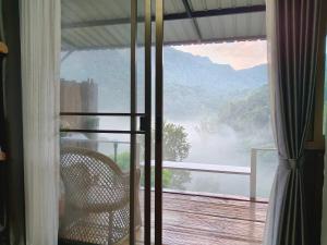 a balcony with a chair and a view of a mountain at บ้านปันสุข ผาหมี in Ban Pha Mi