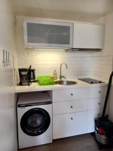 a kitchen with a washing machine and a sink at Atlantique 165 in La Faute-sur-Mer