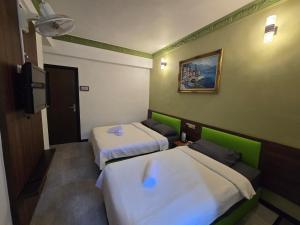 a room with two beds and a flat screen tv at D GAYA HOTEL Cameron Highlands in Tanah Rata +14 photos
