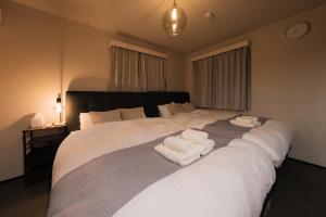 a bedroom with a large white bed with towels on it at Make Your Hotel幡ヶ谷 in Tokyo