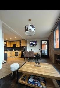 a living room with a table and a kitchen at 'Le Bellevue' coté Montagne BY P&T in Font-Romeu