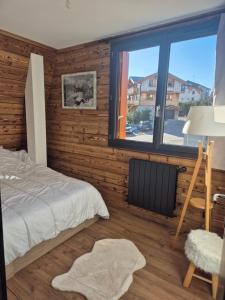 a bedroom with a bed and a large window at 'Le Bellevue' coté Montagne BY P&T in Font-Romeu