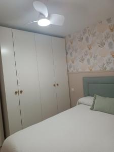 a bedroom with white cabinets and a bed at Cullera Playa de los Olivos Apartment in Faro de Cullera +13 photos