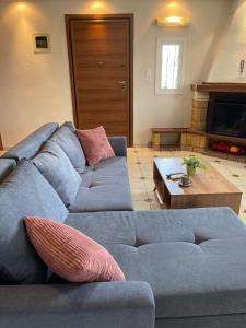 ein Wohnzimmer mit einem blauen Sofa und einem Tisch in der Unterkunft Ioannis Grand House in Áyios Pávlos