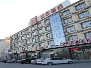 un bâtiment avec des voitures garées devant lui dans l'établissement Home Inn Beijing Yizhuang Kechuang 5th Street, à Pékin