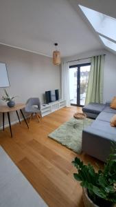 a living room with a blue couch and a table at Apartment am See mit Dachterrasse in Bergkamen