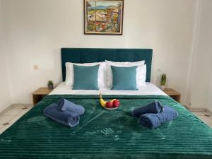 ein Bett mit einer grünen Decke und einer Obstschale darauf in der Unterkunft Ioannis Grand House in Áyios Pávlos + 35 Fotos