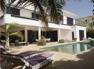 a villa with a swimming pool and a house at Villa Mattéo bord de mer in Mbour