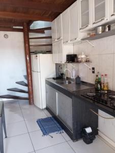 a kitchen with a sink and a refrigerator at La Casa del Monica in Itacaré