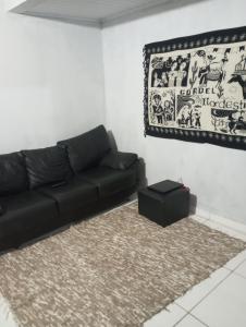 a living room with a black couch and a rug at La Casa del Monica in Itacaré