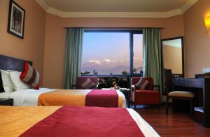 A bed or beds in a room at Hotel Pokhara Grande