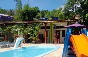 a pool with a slide next to a house at Suites Brejauva in Ubatuba +9 photos
