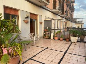 un patio con sillas y plantas en un edificio en Terrazzo fiorito, en Catania 2 fotos más