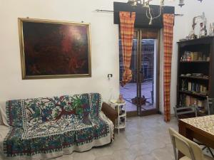 Una sala de estar con un sofá y un cuadro en la pared. en Terrazzo fiorito, en Catania