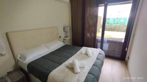 ブール・マダムにあるBonito apartamento con gran jardínのベッドとタオル2枚のある寝室