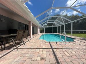 a swimming pool with a table and chairs next to a house at Villa Vera with Lake view in Naples