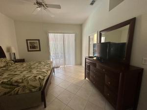 a bedroom with a bed and a television on a dresser at Villa Vera with Lake view in Naples
