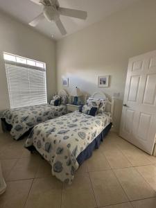 a bedroom with two beds and a ceiling fan at Villa Vera with Lake view in Naples +19 photos