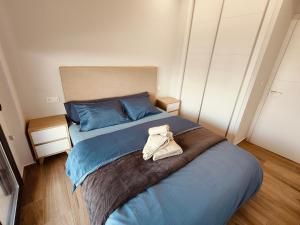 ein Schlafzimmer mit einem blauen Bett mit einem Handtuch darauf in der Unterkunft Claudia Luxury Apartment near the beach with a pool, gym, and secure gated parking in Arenales del Sol + 30 Fotos