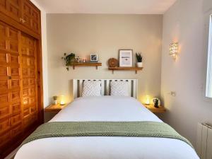 a bedroom with a white bed with two candles at Beautiful Villa Close to Xabia & Moraira in Benitachell