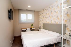 a bedroom with a white bed and a window at Pensión Boutique ADMERA in Santiago de Compostela