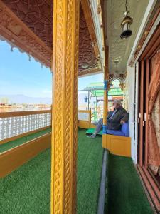 シュリーナガルにあるHeritage Shreen Houseboatの窓を見ながら列車に腰掛けている男