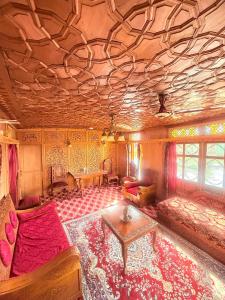 シュリーナガルにあるHeritage Shreen Houseboatのソファとテーブルのあるリビングルーム