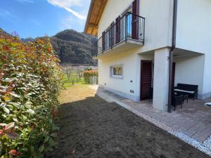 a building with a balcony and a bench in a yard at Casa Claudia lago d'Idro in Bondone