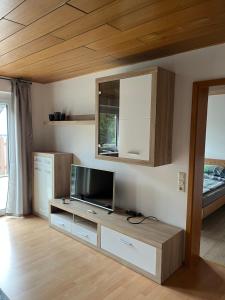 a living room with a television on a table at Ferienwohnung nahe Ulm/Laupheim in Laupheim
