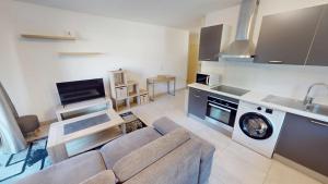 a living room with a couch and a kitchen at Superbe T2 refait à neuf avec balcon vue montagne à un arrêt de Monaco in Roquebrune-Cap-Martin