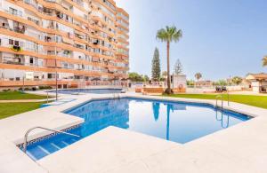 a swimming pool in front of a apartment building at Luxury studio Torremolinos Costa del Sol in Torremolinos