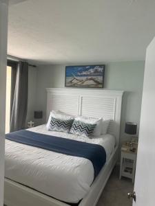 une chambre avec un grand lit blanc avec des oreillers dans l'établissement New Listing-Pristine Cozy Ocean Penthouse Condo, à Marco Island