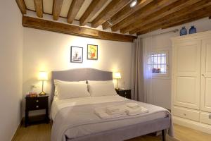 una camera da letto con un grande letto con due comodini di Mascherone Apartment a Venezia Altre 26 foto