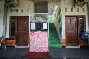 an entrance to a building with two doors and stairs at Capital O 2258 Santana Syariah Guest House in Solo
