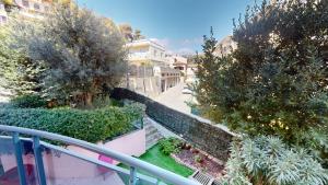 a balcony view of a street with trees and bushes at Superbe T2 refait à neuf avec balcon vue montagne à un arrêt de Monaco in Roquebrune-Cap-Martin