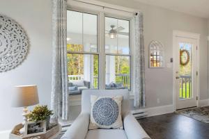 een woonkamer met een bank en een raam bij Le Papillon - 77 Butternut in Cherry Valley