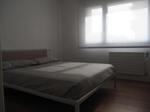 a bed in a white room with a window at Alloggio il Melograno in Pordenone +22 photos