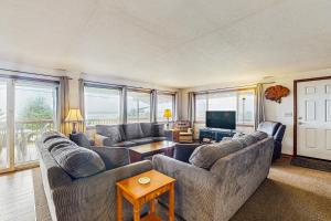 a living room with couches and a flat screen tv at Falcon's Nest in Twin Rocks