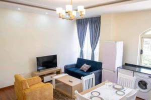 a living room with a blue couch and a table at Yani apartment in Addis Ababa