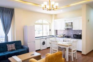 a kitchen and living room with a table and a blue couch at Yani apartment in Addis Ababa