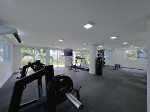 Un gimnasio con cintas de correr y máquinas en una habitación. en Apartamento em Arraial D`Ajuda com Piscina Sauna Academia, en Porto Seguro