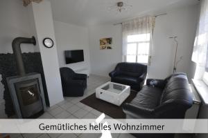 a living room with a couch and a fireplace at Ferienhaus Anno 1912 in Klüsserath