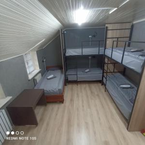 a room with three bunk beds and a table at Friends Hostel in Chişinău +12 photos