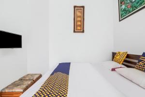 a bedroom with a bed with a tv and pillows at Hotel O Villa Tirta Melati Syariah in Banjar +21 photos